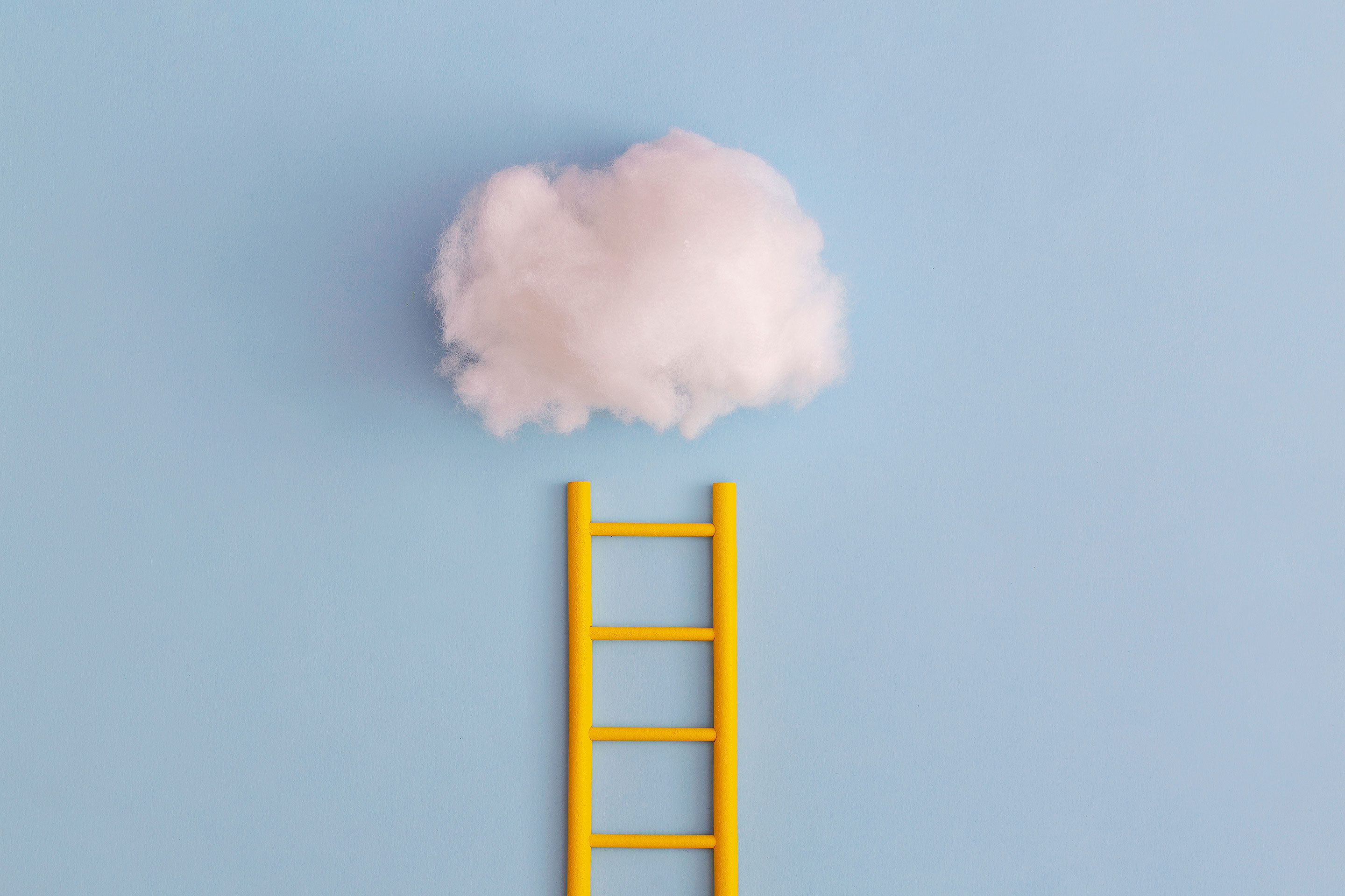 A bright yellow ladder reaches to a cloud, indicating reaching high goals