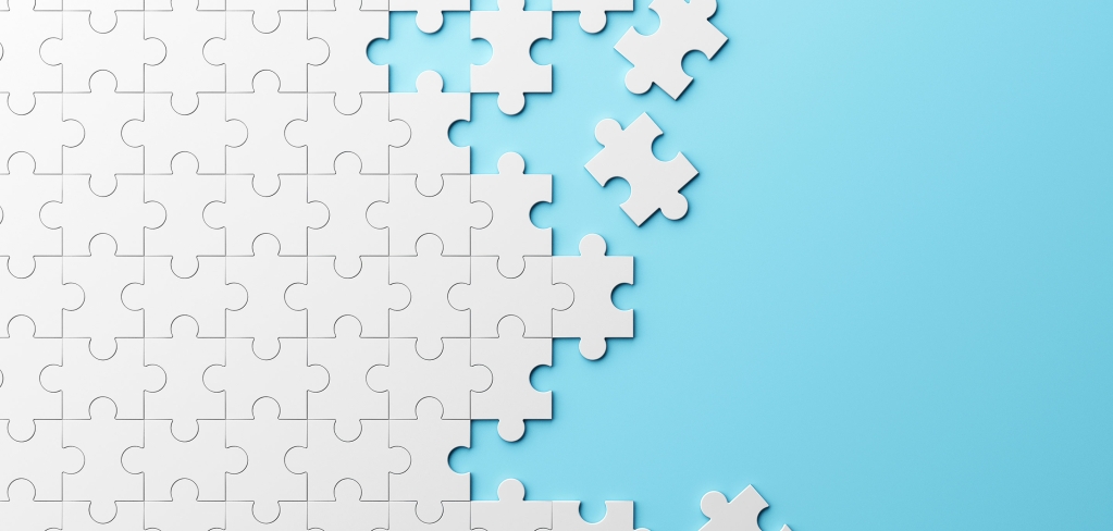 White puzzle pieces on a blue background, illustrating complexity
