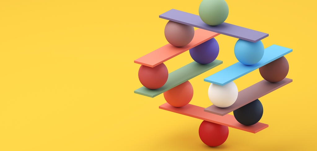 A teetering stack of multi-colored balls and planks, suggesting balance and interdependency