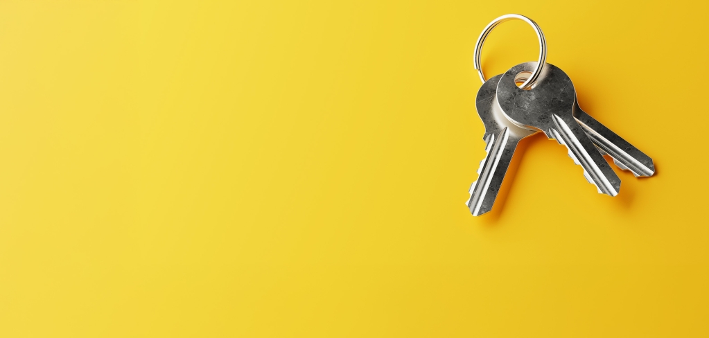 A group of silver keys on a bright yellow background.