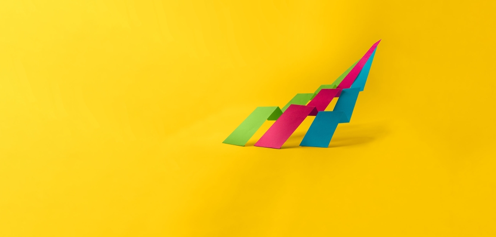 Ribbons of bright pink, blue, and green on a bright yellow background.