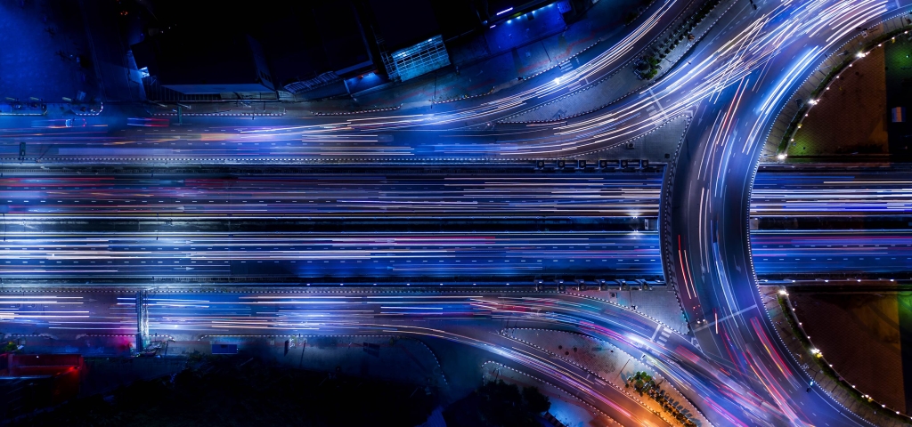 From above, cars speeding along interconnecting highways resemble the flow of data building an ecosystem