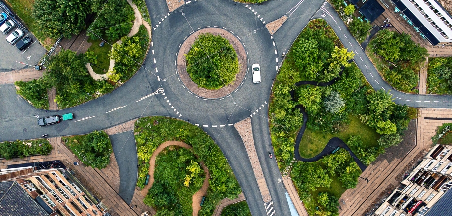 An aerial shot of a roundabout intersection, showing cars going in different directions as a metaphor for adaptability
